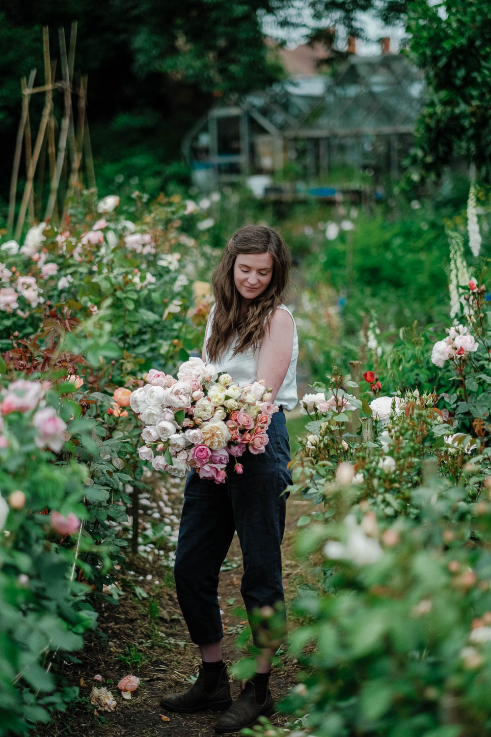 Becky in the cutting garden holding an armfull of British roses