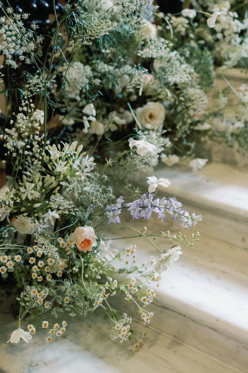 Floral arrangement cascading down marble staircase in Mayfair, London. Photo ©Jessica Lily Photography