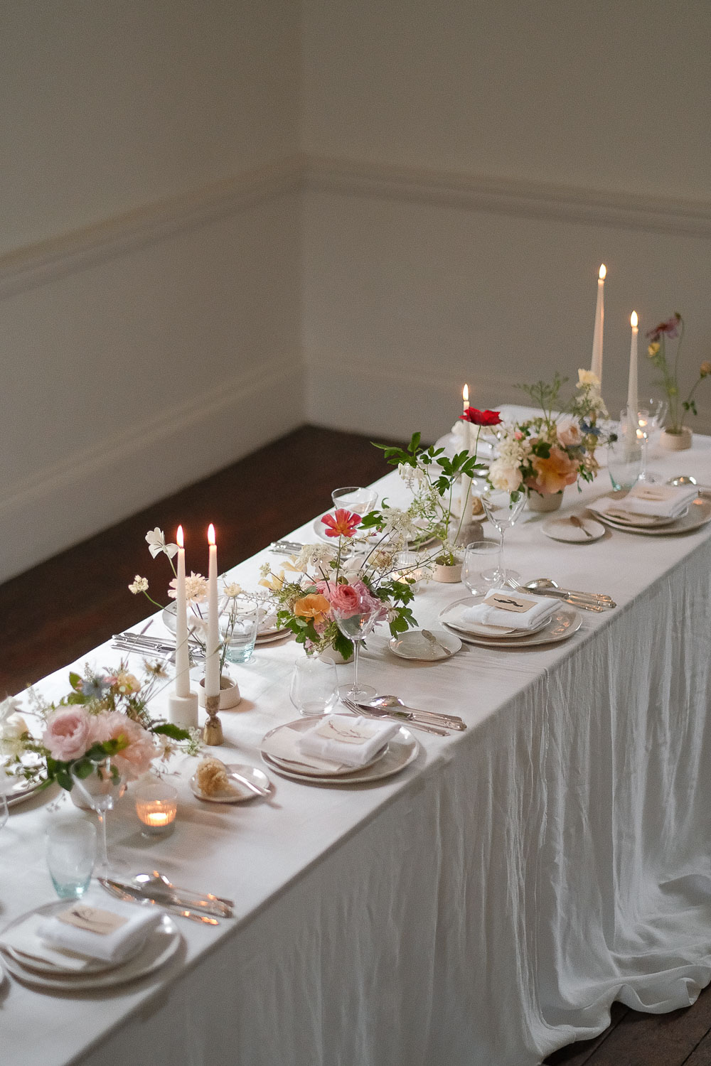 Tabel setup showing bowl and kenzan arrangements with candles and place settings