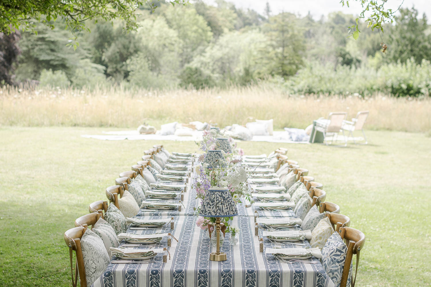 Table set outside with Morrise & Co. tablecloth and floral arrangments running down the middle. Photo ©Claire Menary